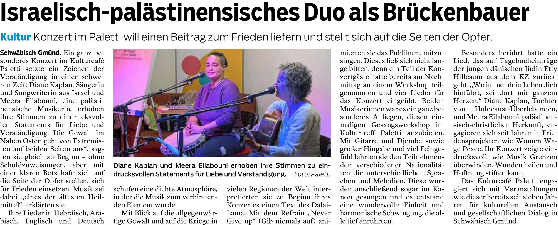 Das Bild zeigt einen Zeitungsausschnitt mit einem Artikel und einem Foto. Überschrift: Israelisch-palästinensisches Duo als Brückenbauer Untertitel: Kultur – Konzert im Paletti will einen Beitrag zum Frieden liefern und stellt sich auf die Seiten der Opfer. Artikeltext (Zusammenfassung): Der Artikel berichtet über ein besonderes Konzert im Kulturcafé Paletti in Schwäbisch Gmünd. Die israelische Sängerin Diane Kaplan und die palästinensische Musikerin Meera Eilabouni gaben gemeinsam ein Konzert als Zeichen für Verständigung und Frieden. Sie sangen Lieder in mehreren Sprachen (Hebräisch, Arabisch, Englisch und Deutsch) und erklärten, dass sie sich auf die Seite der Opfer stellen, ohne Schuldzuweisungen. Ein Teil des Publikums hatte am Nachmittag in einem Workshop vier Lieder einstudiert, die sie gemeinsam aufführten. Besonders bewegend war ein Lied nach Texten der Jüdin Etty Hillesum aus dem KZ. Beide Musikerinnen engagieren sich seit Jahren in Friedensprojekten. Foto: Auf dem Foto sitzen zwei Frauen nebeneinander auf einer kleinen Bühne. Links spielt eine Frau mit kurzen Haaren (Meera Eilabouni) eine Trommel und singt in ein Mikrofon. Rechts spielt eine Frau mit lockigen Haaren (Diane Kaplan) Gitarre und singt ebenfalls. Hinter ihnen sind bunte Wände zu sehen. Bildunterschrift: Diane Kaplan und Meera Eilabouni erhoben ihre Stimmen zu eindrucksvollen Statements für Liebe und Verständigung.